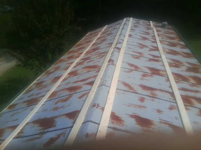 Rusted metal roof panels with new wood purlins before replacement — Storm Damage Roof Repair in Thompsonville by Roofing Brothers