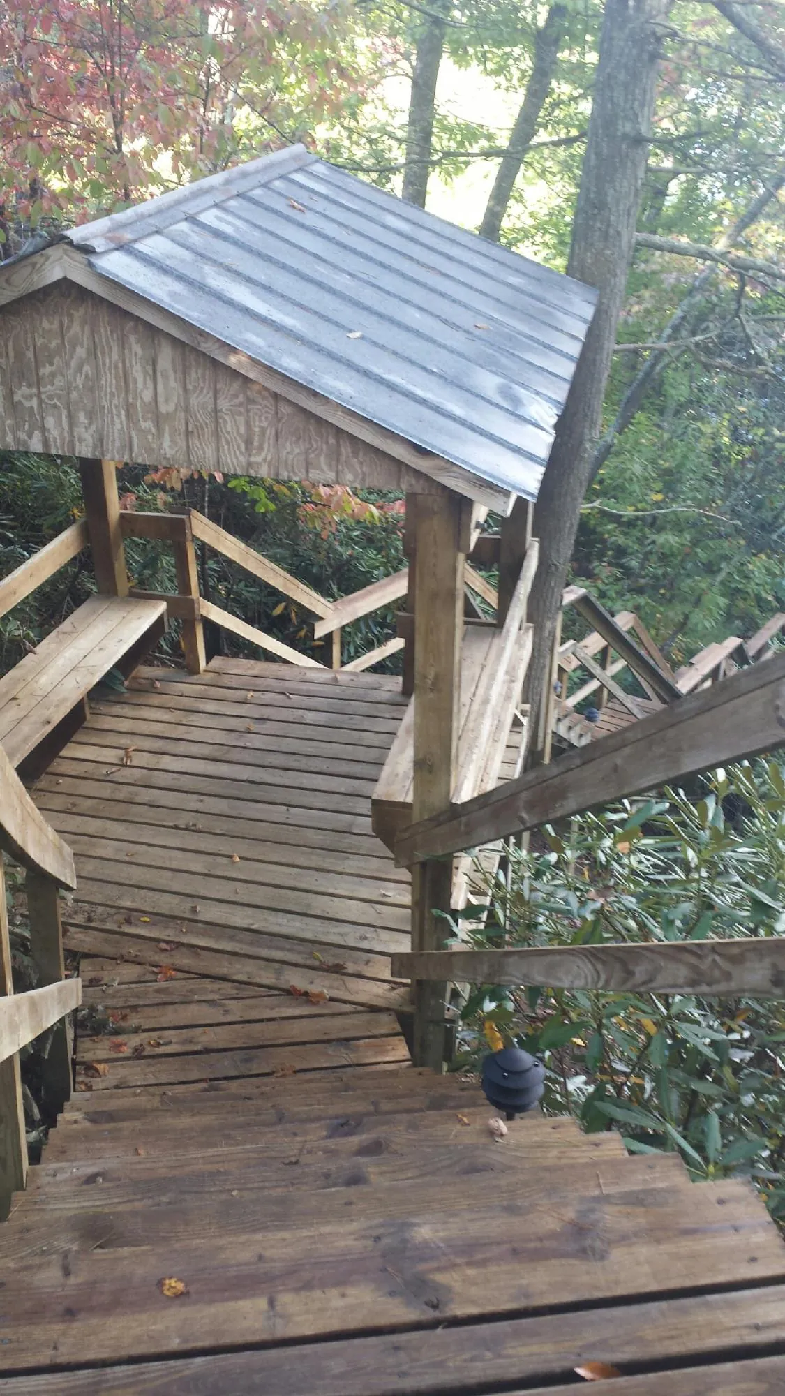 Metal roofed shelter over wooden steps on a wooded walkway — Skylight Repair & Installation work by our crew in Thompsonville